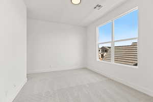 Empty room featuring light colored carpet