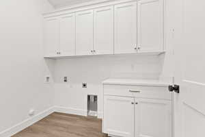 Laundry room featuring light wood-type flooring, cabinet space, washer hookup, and electric dryer hookup