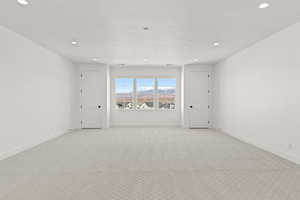 Carpeted empty room with recessed lighting