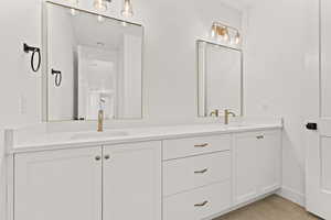 Bathroom with double vanity and light tile patterned floors
