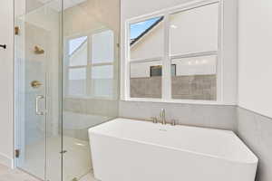 Full bath featuring a freestanding bath and a stall shower