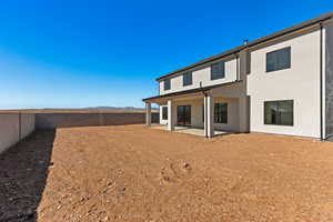 Back of property with a mountain view, a fenced backyard, stucco siding, and a patio area