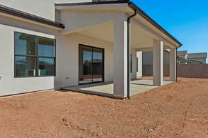 Rear view of property featuring a patio and stucco siding