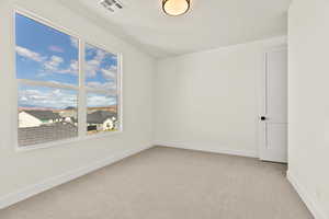 Empty room with light carpet and baseboards