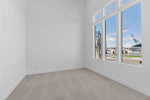 Unfurnished room featuring light carpet and a residential view