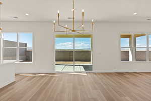 Unfurnished dining area featuring a chandelier, recessed lighting, and light wood-style flooring