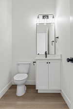 Half bath with vanity and light wood-style flooring