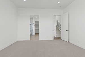Unfurnished bedroom featuring recessed lighting, a spacious closet, and light carpet