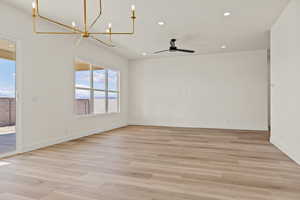 Empty room featuring a chandelier, light wood-style floors, recessed lighting, and ceiling fan