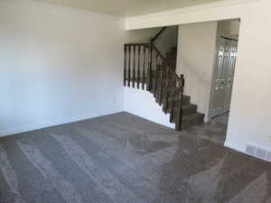 Staircase with carpet floors and ornamental molding