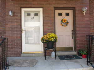 Property entrance featuring brick siding