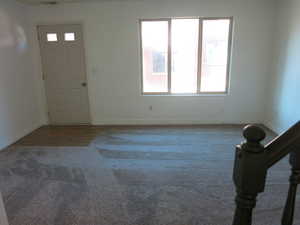 Foyer entrance featuring carpet flooring and baseboards