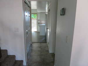 Hallway with light tile patterned floors and stairway