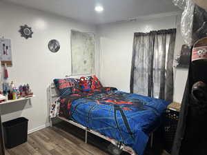 Bedroom with dark wood finished floors and baseboards