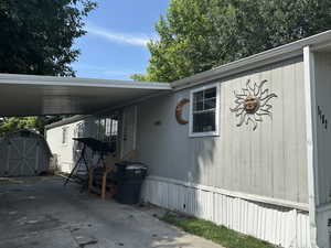 View of side of home featuring a storage shed and a carport