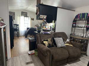Living room with light wood-type flooring and vaulted ceiling