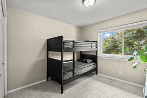 Bedroom featuring light carpet and baseboards