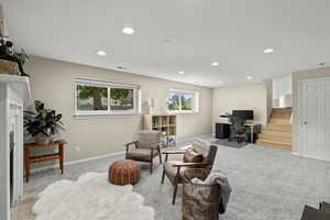 Living area featuring stairway, a desk, light colored carpet, a fireplace, and recessed lighting