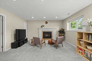 Living area featuring recessed lighting, light carpet, and a fireplace