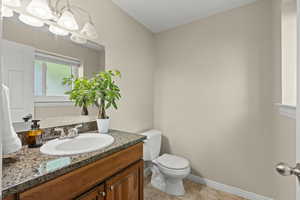 Half bathroom featuring vanity, light tile patterned floors, and a chandelier
