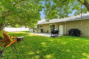 Back of property featuring a patio, brick siding, and a shingled roof