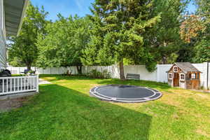 Fenced backyard with an outbuilding and a trampoline