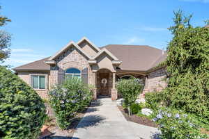 View of front of house featuring stone siding, brick siding, and roof with shingles