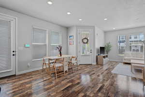 Dining space with recessed lighting, dark wood-style flooring, and a textured ceiling