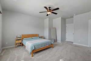 Bedroom with light colored carpet and a ceiling fan