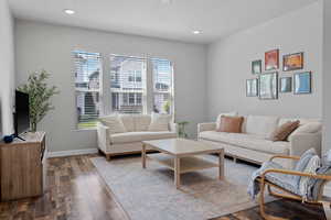 Living area featuring dark wood-type flooring and recessed lighting