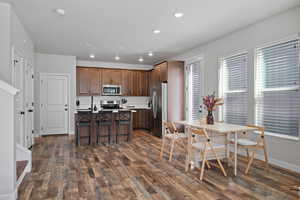 Kitchen with recessed lighting, light countertops, appliances with stainless steel finishes, a breakfast bar area, and a center island