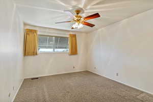 Carpeted empty room with baseboards and ceiling fan
