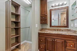 Full bathroom featuring vanity and a closet