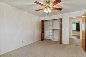 Unfurnished bedroom with light colored carpet, a closet, and ceiling fan