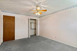 Unfurnished bedroom featuring carpet flooring, a ceiling fan, and a closet