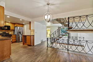 Kitchen with recessed lighting, appliances with stainless steel finishes, decorative backsplash, wood finished floors, and pendant lighting