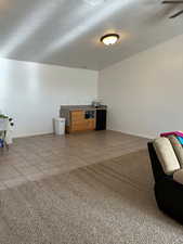 Living area with a textured ceiling and light tile patterned flooring