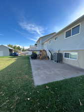 Rear view of property featuring a patio area, a lawn, stairway, and a deck