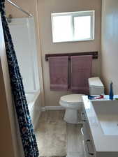 Full bath with vanity, shower / tub combo, and light wood-type flooring