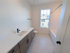 Bathroom with vanity, bathing tub / shower combination, and light tile patterned floors