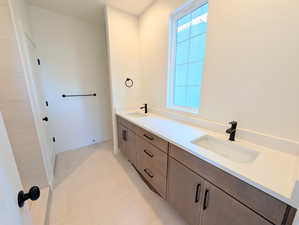 Primary Bathroom featuring double vanity and baseboards