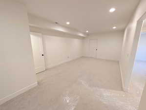 Basement family room with recessed lighting and baseboards