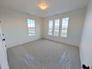 Upper secondary room with light colored carpet and baseboards