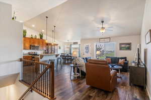 Living room featuring dark wood-style floors, ceiling fan, recessed lighting, and high vaulted ceiling