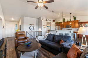 Living room featuring dark wood-style floors, a ceiling fan, high vaulted ceiling, and recessed lighting
