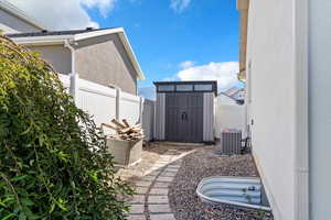 View of property exterior with a shed and stucco siding