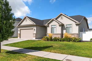 View of front of house featuring stucco siding, driveway, an attached garage, and brick siding