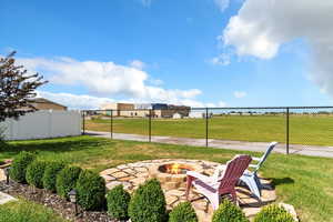 View of yard with an outdoor fire pit and a patio