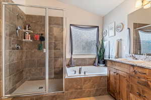 Bathroom with vanity, a shower stall, a bath, lofted ceiling, and tile patterned flooring