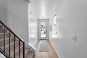 Entryway featuring a textured ceiling, stairs, and wood finished floors